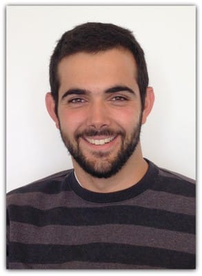 A profile photo of a man in his late 20s with dark hair and a dark trimmed beard, smiling at the camera.