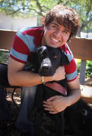 Photo of Belo Cipriani and his guide dog, Oslo, a black lab.