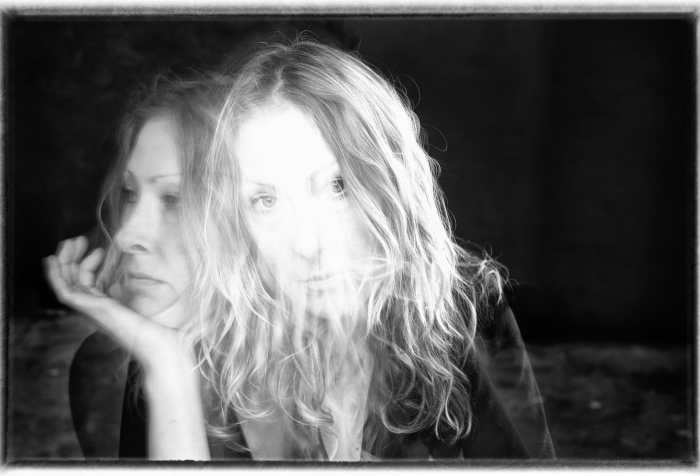 Black and white double exposure head-shot of Anna Berry, one in which she is looking forward, and one in profile.