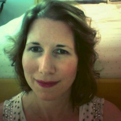 Photo of a middle-aged white woman with brown shoulder-length hair smiling at the camera.