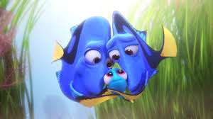 An animated scene from the Pixar film "Finding Dory." Two parents who are blue tang fish embracing their little baby fish in the center.