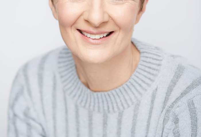 A headshot of Pia Justesen a white Danish woman with short brown hear and wearing a light blue sweater.