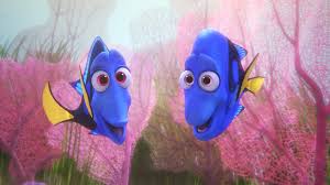 An animated scene from the Pixar film "Finding Dory." Underwater coral reef in the background with two royal blue tang fish